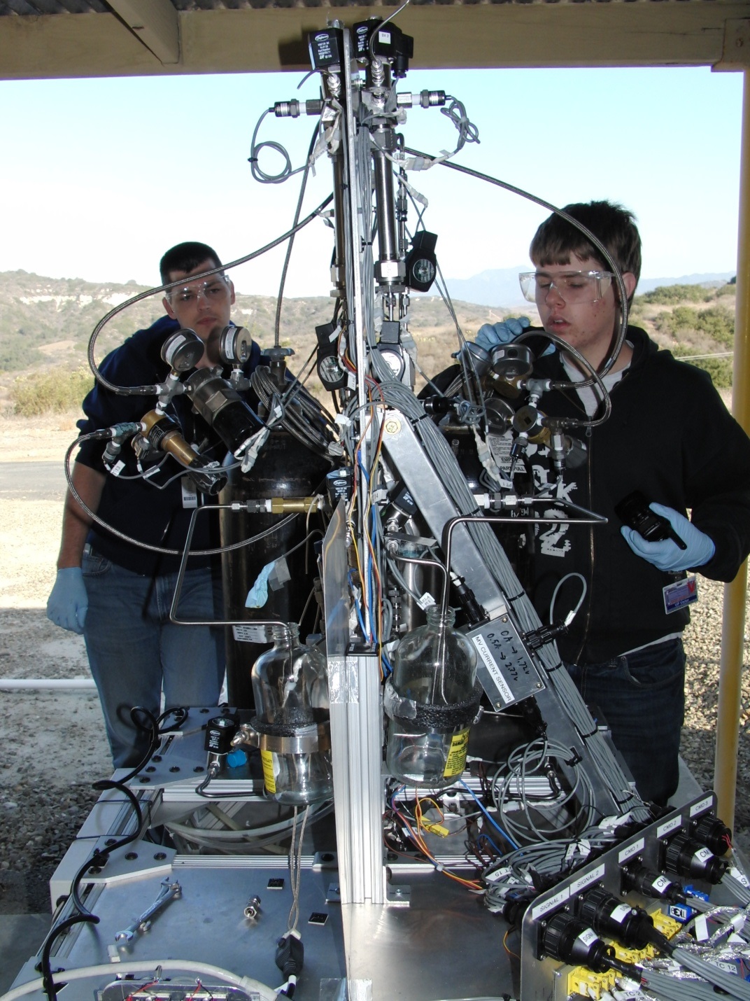CSULB student Christopher Anderson (right) and Northrop Grumman Engineer Victor Zankich set up the oxidizer pressure regulator.